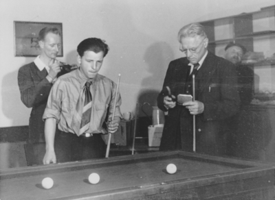 876593 Portret van drie mannen die aan het biljarten zijn, vermoedelijk tijdens een vaderavond in een zaaltje van het ...